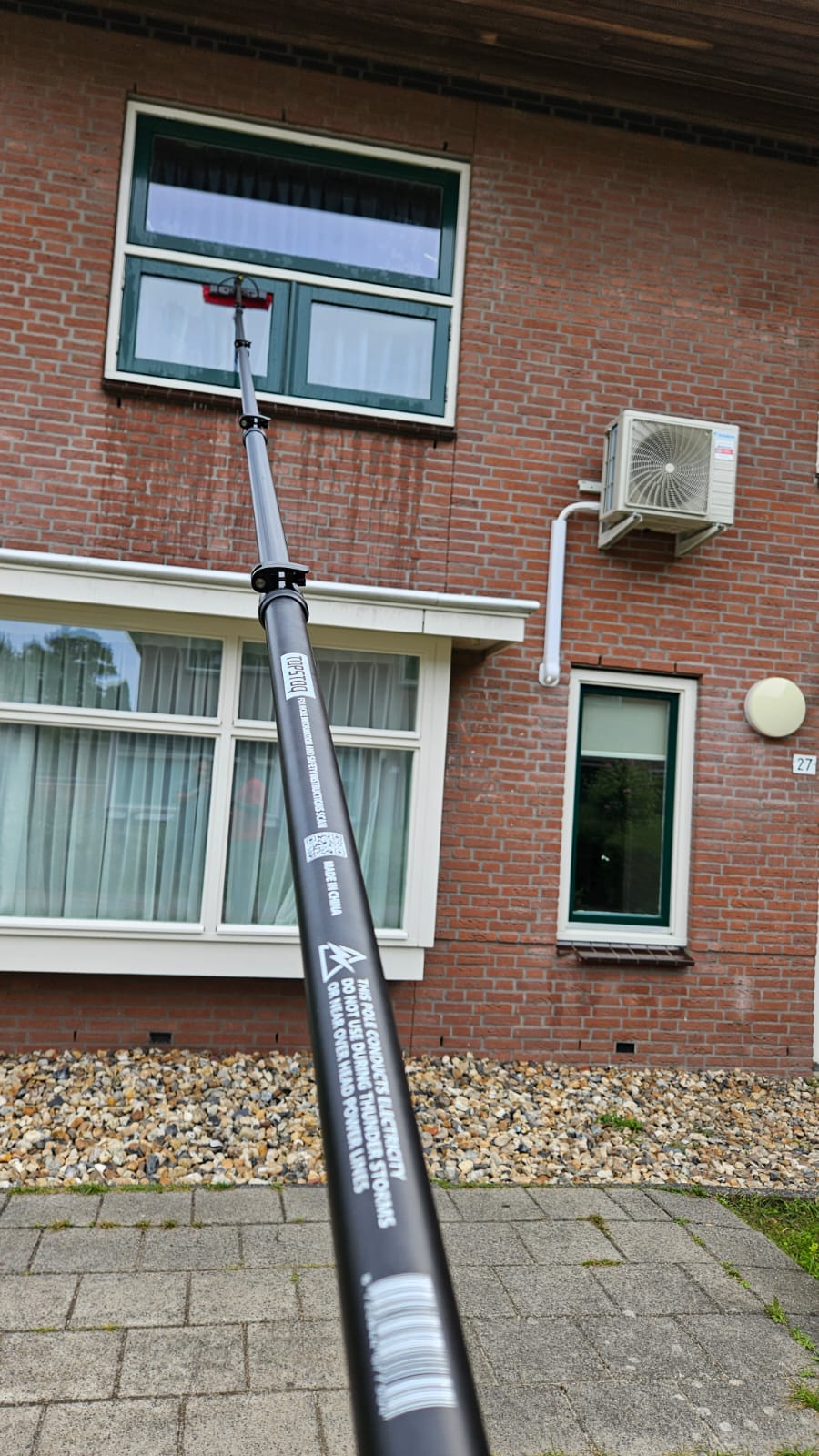 Professionele glazenwasser gebruikt de Topstoq carbon telescoopsteel van 6,5 meter om moeiteloos ramen op de eerste verdieping te reinigen. Lichtgewicht, stabiel en ideaal voor werken op hoogte.