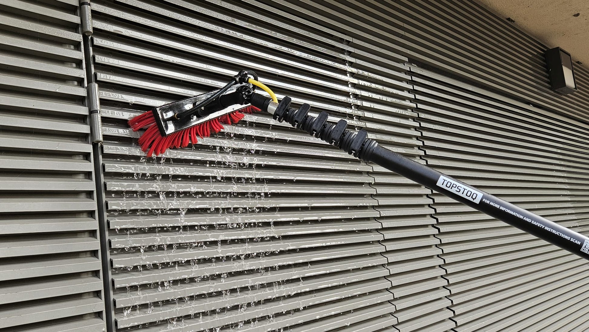 Close-up van de Topstoq carbon telescoopsteel met waterdoorvoerborstel met zachte haren, ideaal voor het veilig reinigen van kwetsbare geveloppervlakken zonder krassen.