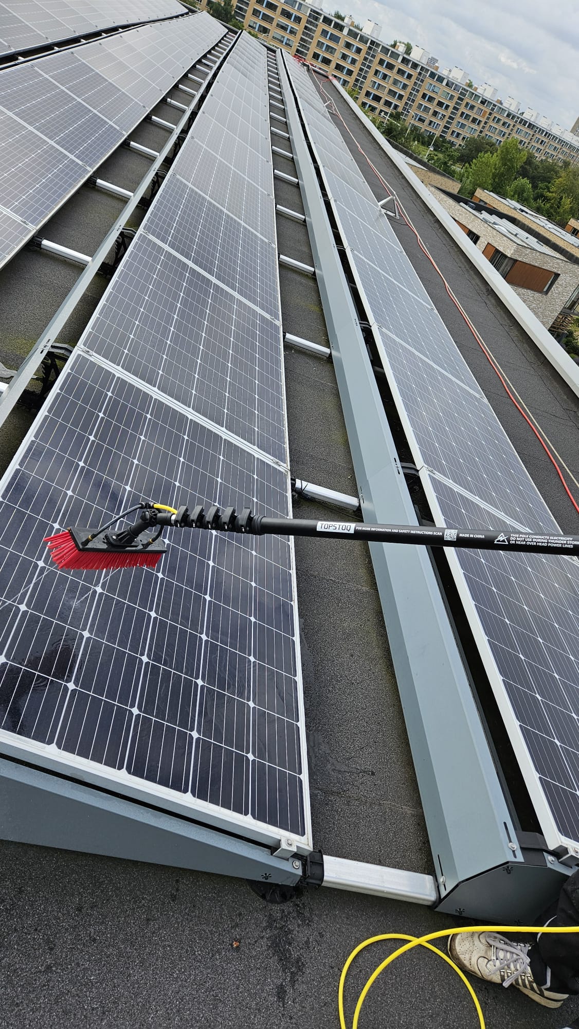 Close-up van de Topstoq carbon telescoopsteel met professionele borstel en twee fijne sproeiers die gelijkmatig water verdelen tijdens het reinigen van zonnepanelen. Lichtgewicht en stabiel voor professioneel gebruik.